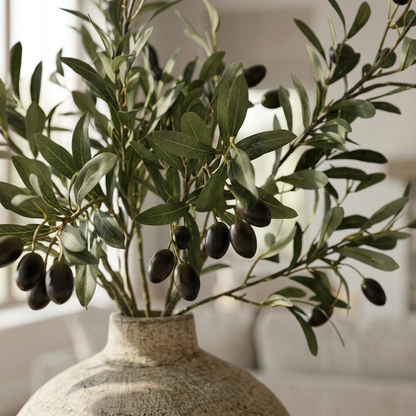 Detail of narrow artificial olive leaves and dark decorative olives